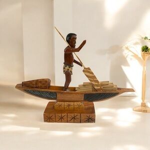 Vintage African wooden boat with figure and goods. 
11.75”T x 14.5”W